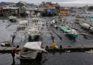 A Filipino man reinforces his makeshift home at a fish port in Navotas, north of Manila, Philippines on Monday May 9, 2011. Tropical storm Aere threatened the Philippines' agricultural north Monday after pummeling the eastern coast and the capital with fierce winds and rain that sparked floods and landslides, officials said.(AP Photo/Aaron Favila)